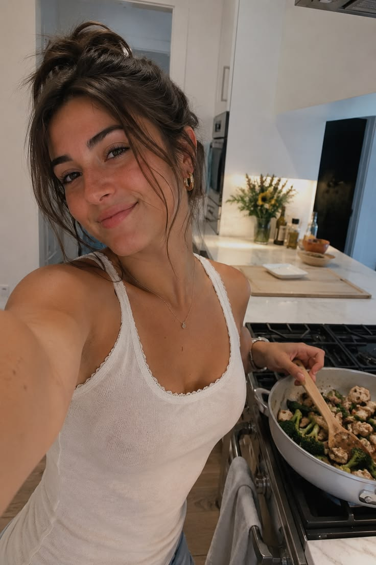 Pinterest inspiration: a woman taking a cooking selfie in a white tank
