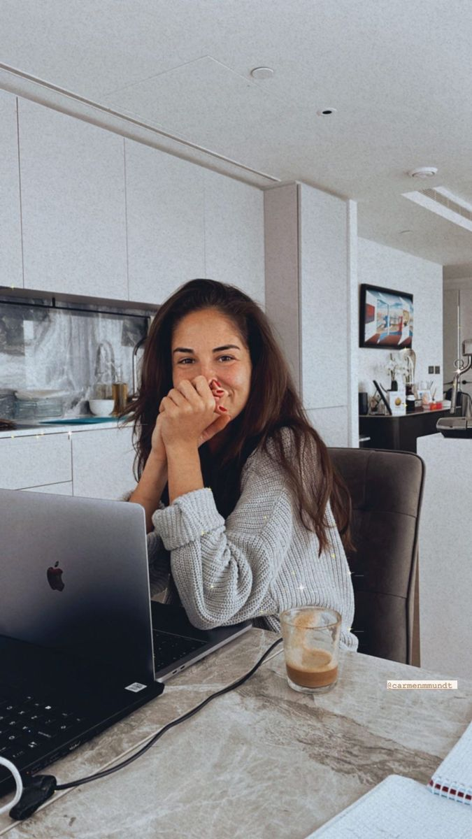 Inspiration photo: a woman smiling at her laptop in a bright kitchen, iced coffee beside her